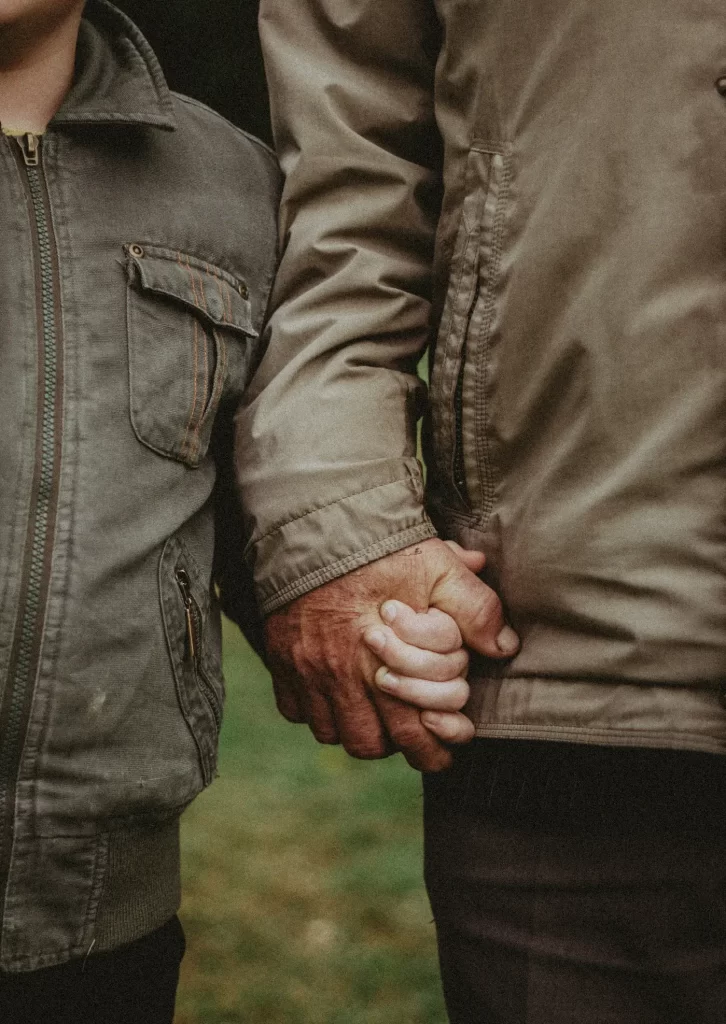 closeup of child and adult holding hands